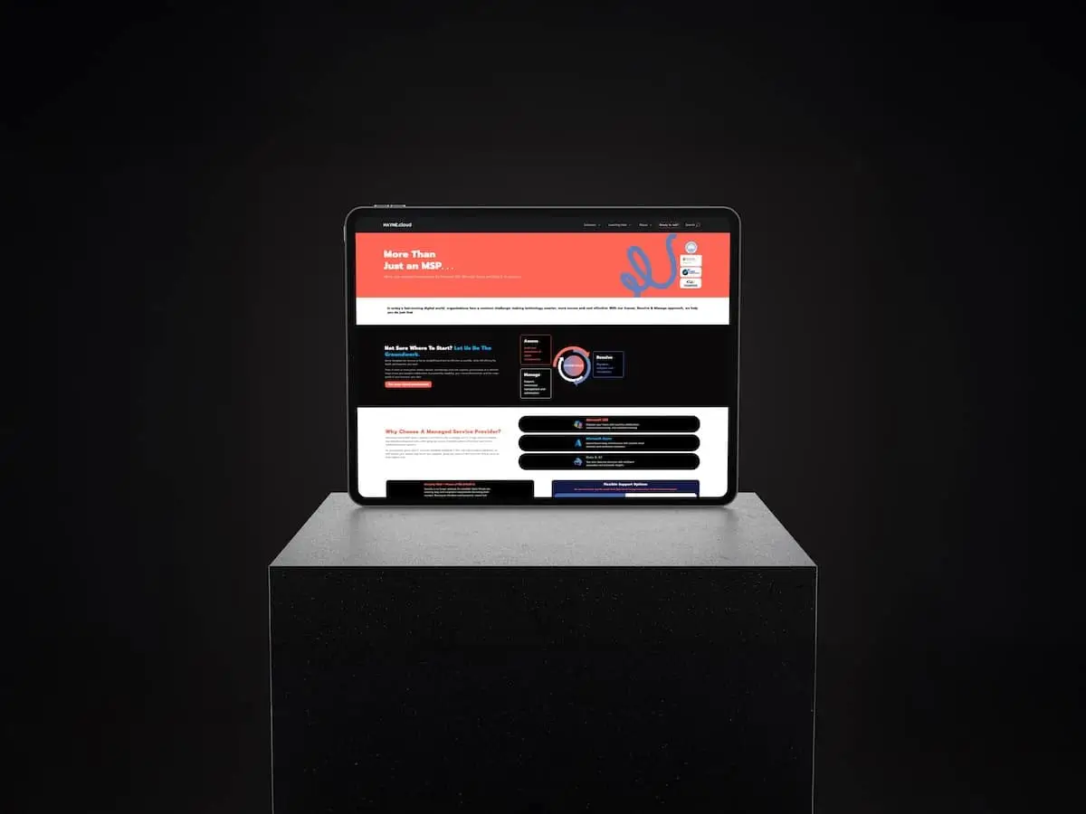 Tablet on a dark pedestal displaying a vibrant multi-section website with a red header on a black background.