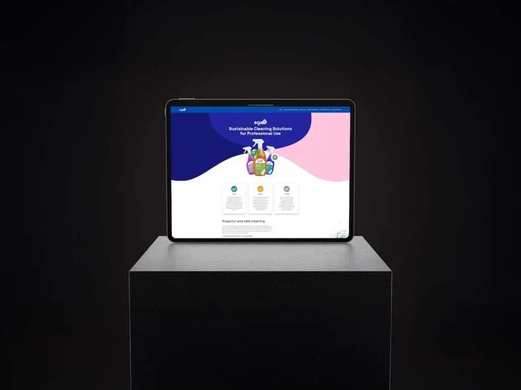 Tablet on a pedestal displays a colorful cleaning products webpage against a dark backdrop.