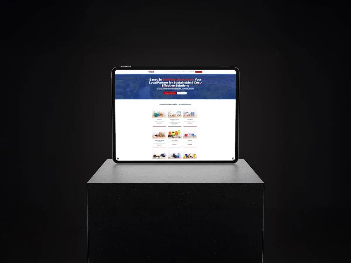 Tablet on a dark pedestal displaying a blue website header and grid of category tiles on screen