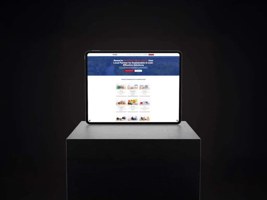 Tablet on a dark pedestal displaying a blue website header and grid of category tiles on screen
